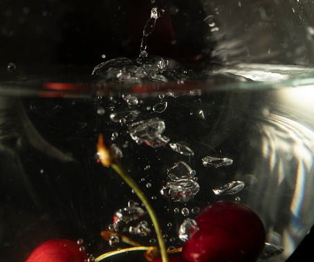 Cherries in a water bowl, close-up. water splash.