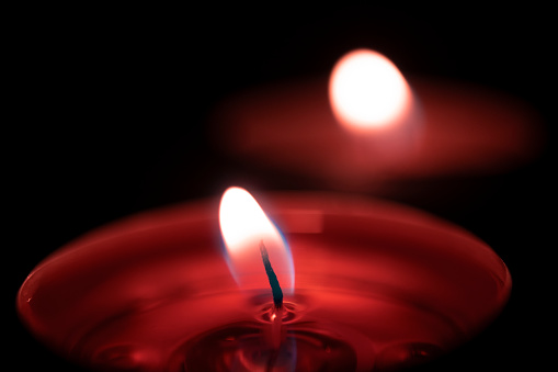 Burning candles flame close up black background