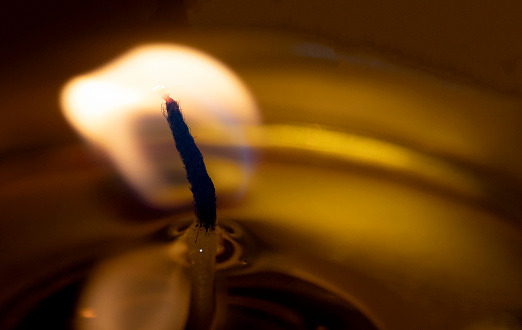 Burning candle flame close up black background