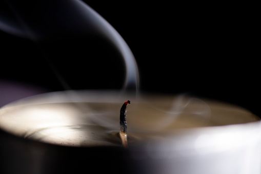 Smoke from the flame of an extinguished candle, close-up.