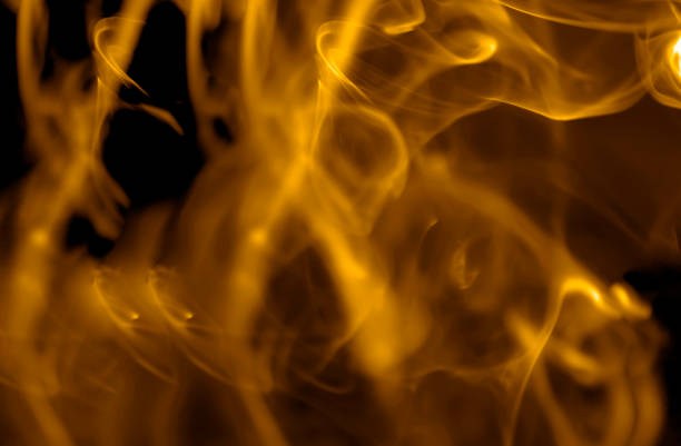 yellow flame colored smoke, on a black background stock photo