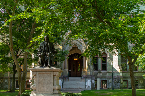 Philadelphia, USA - June 20, 2022. Statue of Benjamin Franklin in front of College Hall, the oldest building, in the campus of University of Pennsylvania, Philadelphia, USA