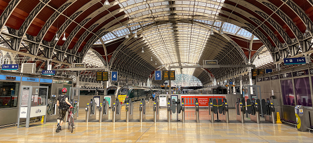 London, England - June 2022: Deserted platform at the ticket barriers on the concourse of Paddington railway station on the day of strike action on the rail network