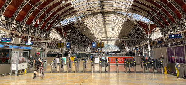 Concourse at London Paddington railway station on the day of a rail strike London, England - June 2022: Deserted platform at the ticket barriers on the concourse of Paddington railway station on the day of strike action on the rail network striker stock pictures, royalty-free photos & images