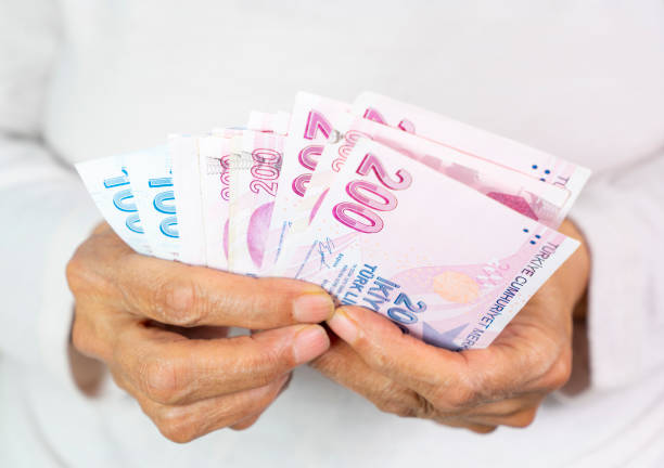 istock old women Hands holding Turkish Lira banknotes 1405107911