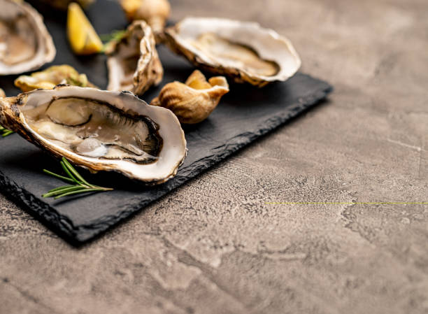istock Set of oysters and snails on black platter 1405108338