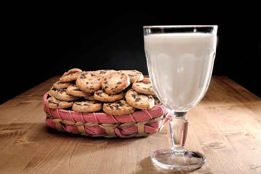Cookies and glass of milk on wooden table