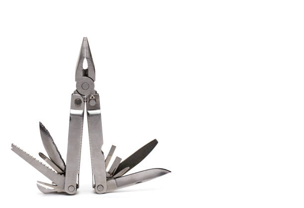 Close up of professional large multitools folding knife with various blades screwdrivers saw and pliers on white clay background