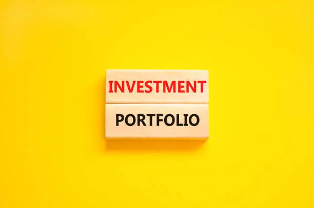 Photo of Investment portfolio symbol. Wooden blocks with concept words Investment portfolio on beautiful yellow background. Business investment portfolio concept. Copy space.