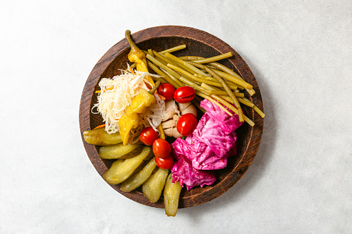 Different marinated vegetables pickles on wooden plate. Copy space.