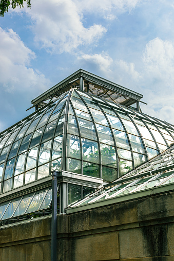 The top portion of a large greenhouse against a blue sky