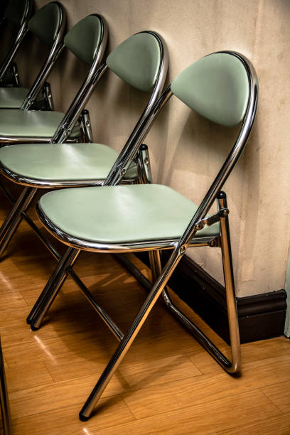 istock Light green iron folding stools are neatly arranged by the wall 1405141062