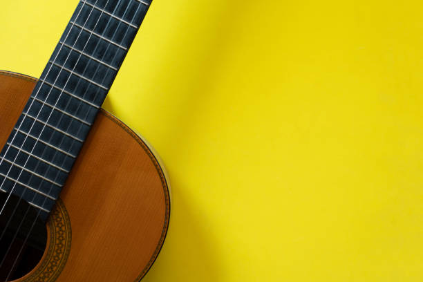 istock old classic guitar on yellow table background, music concept 1405141215