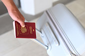 A hand holding Russian passport and suitcase