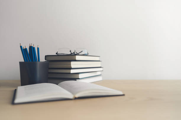 istock Open book and stack of textbook on table. Business success idea of learning, planning or working. Education concept of studying and knowledge cognition. Businessperson or student training skill 1405145365