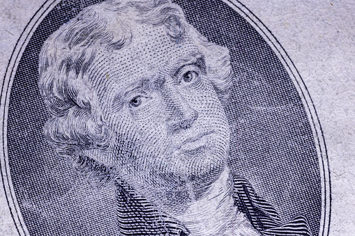 Close up portrait of George Washington from dollar bill against black background.