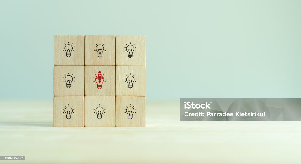 Launching idea, startup business concept. Beyond competitors, good plan, successful goal concept. Wooden cubes with "rocket launch" and other icon on grey background and copy space. Innovation banner. Most Valuable Player Stock Photo