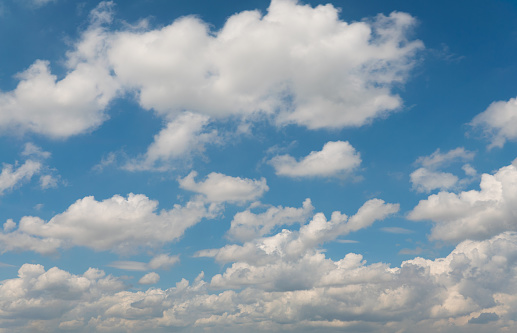 A beautiful panorama of blue sky with white fluffy clouds. Made from several stitched frames from a 1DsMkIII.