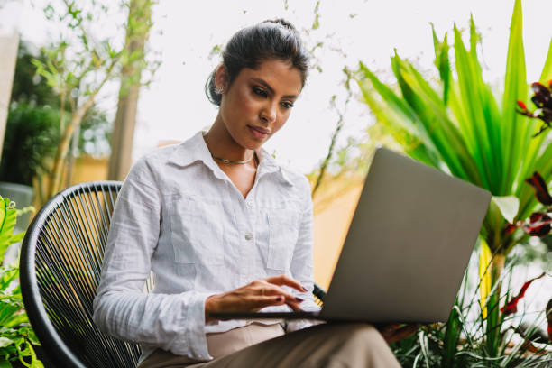istock Nomad on work. Confident young Latin woman making video call on laptop while sitting by window in cafe. 1405154732