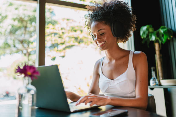 istock Nomad on work. Confident young Latin woman making video call on laptop while sitting by window in cafe. 1405155591