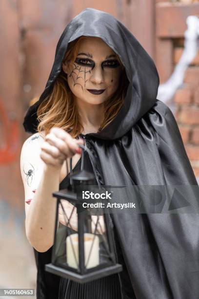 explosión Articulación Ascensor Atractiva Mujer Hermosa Con Un Disfraz De Halloween Capa Negra Y Maquillaje  Aterrador Joven Con La