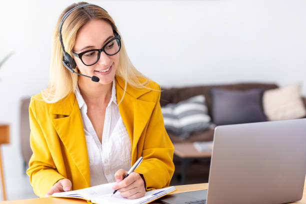 istock Woman customer support call center operator or receptionist in headset consulting client using video call. Female student using laptop computer, studying, distance learning, Online education concept 1405163297