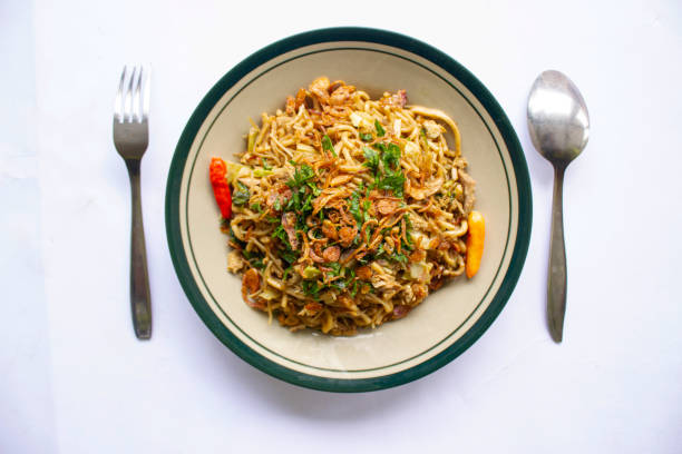 istock Mie Goreng Jawa or bakmi jawa or java noodle withspoon and fork. Indonesian traditional street food noodles from central java or Yogyakarta, indonesia 1405170408