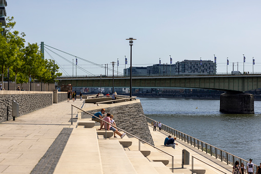 Cologne, Germany - Jun 18th 2022: Kennedy Ufer in Cologne attracts people to spend sunny days near Rhine river.