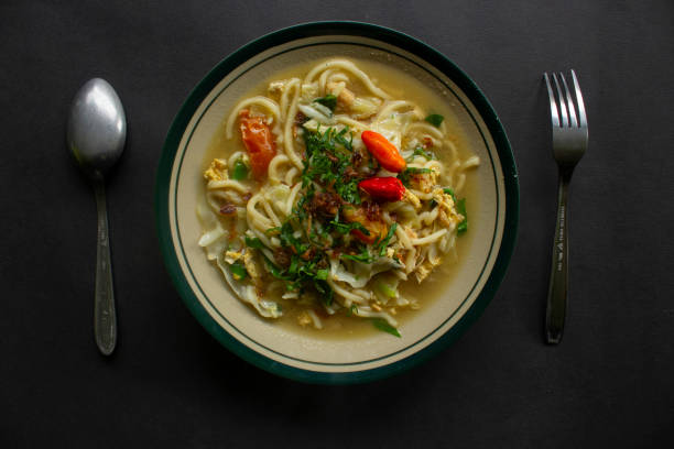 istock Mie godog Jawa or bakmi jawa or java noodle or Mie rebus or boiled noodles with spoon and fork. Indonesian traditional street food noodles from java, indonesia on white backgroud 1405171769