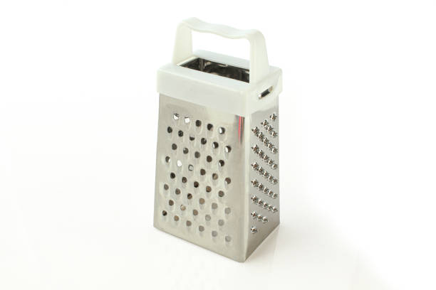 Small mettallic grater with white plastic handle isolated. Slicing kitchen equipment
