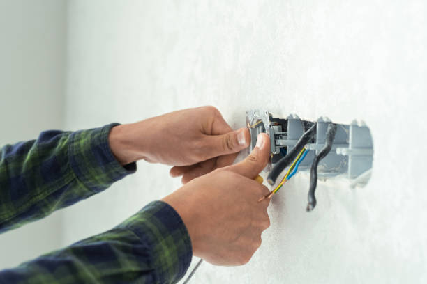 istock Electrician mounts a new socket on a white wall. Renovation process in a new apartment 1405176563