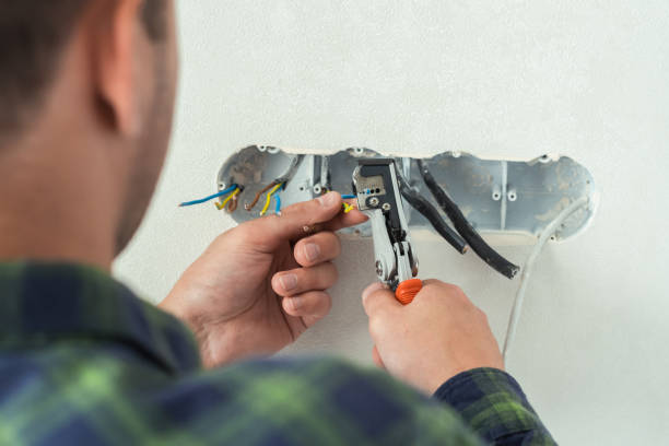 istock Electrician mounts a new socket on a white wall. Renovation process in a new apartment 1405176571