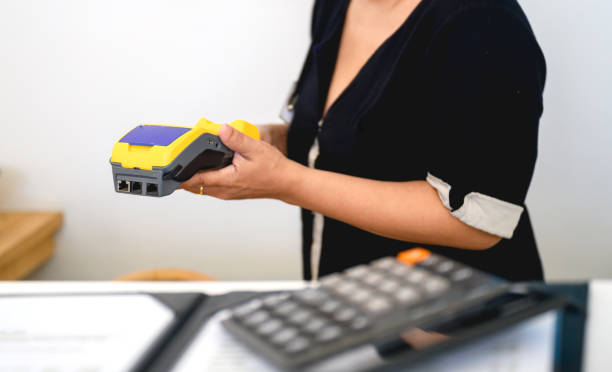 istock Woman holding wireless credit card reader 1405179879