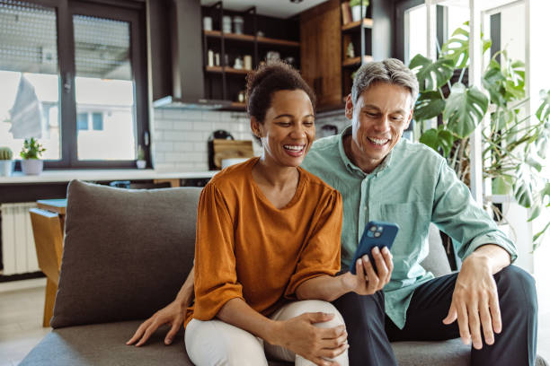 dojrzała para za pomocą inteligentnego telefonu w domu - couple caucasian bonding connection zdjęcia i obrazy z banku zdjęć