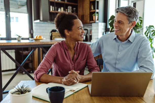 istock Happy mature couple using laptop at home 1405181357