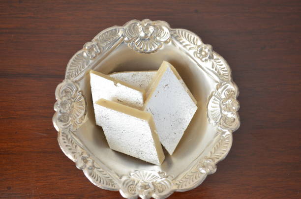 カジュ・カトリは、カジュ・バルフィとも呼ばれ、バルフィに似たインドのデザートです。砂糖、カシューナッツ、ドライフルーツ、ギー、サフランから作られ、一口サイズのダイヤモンド� - diamond shaped ストックフォトと画像