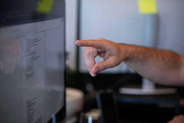 istock Close-up of a man pointing his finger at computer screen 1405183789