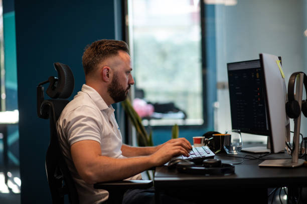 istock Attractive young man at work, sitting at his desk 1405184084