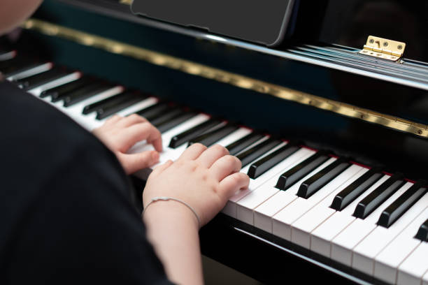 istock kid hands press piano key for music online learning 1405185264