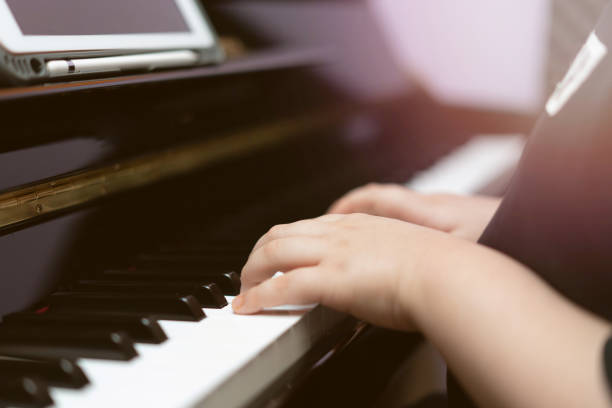 istock kid hands press piano key for music online learning 1405185320