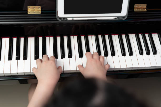istock kid hands play piano key 1405185391