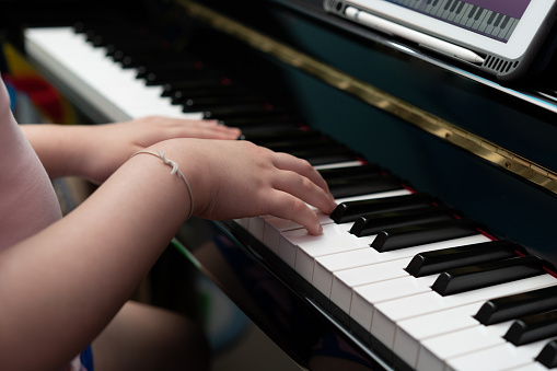 kid hands play piano key