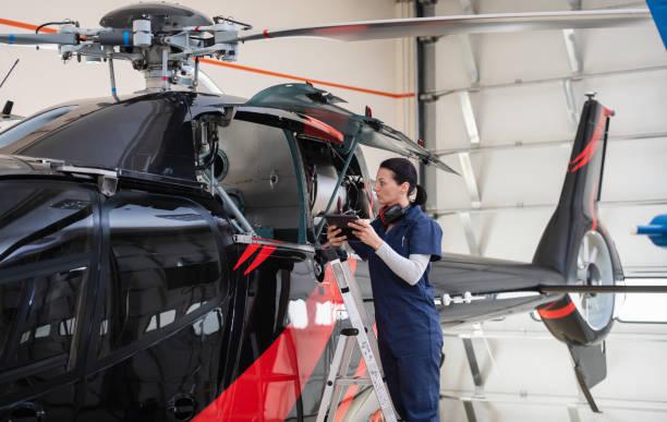 Female Aero Engineer Working On Helicopter In Hangar