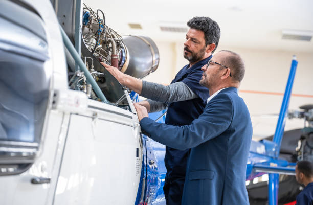 istock Aeronautical Engineer And Helicopter Owner Talking In Hangar 1405189228
