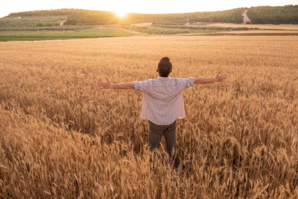 istock young man with open arms in wheat field 1405189968