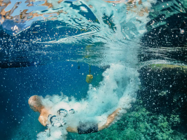 istock Underwater shot of diver breaking water surface 1405193650