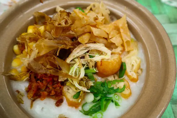 porridge served on hot claypot topped with chicken, sweet corn, skipjack tuna, tofu, green onions, crackers, dumplings and broth"