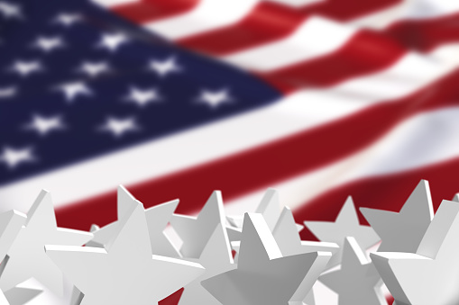 National celebrations of United States concept. 3D rendered white color stars in front of defocus American Flag. Large copy space on defocus area.