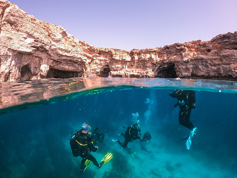 Group of male scuba divers exploring and enjoying sea life