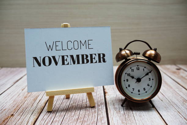 istock Welcome November text message with alarm clock on wooden background 1405197846